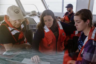 Four researchers inside a research vessel have a meeting.